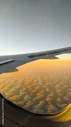 Wing of an aircraft during a flight at sunset horizon