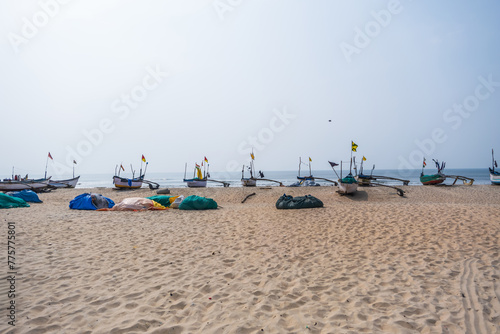 old fishing boats in sand on ocean in India on blue sky background