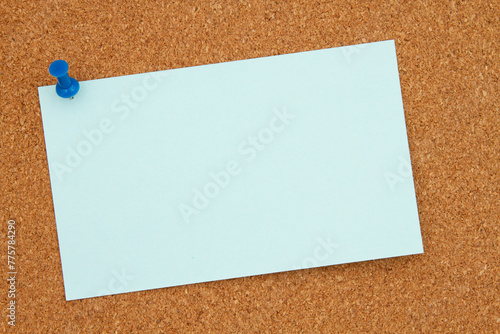 Corkboard with blue note and pushpin background