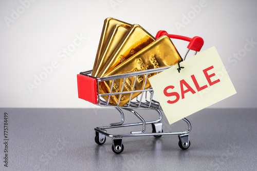Real gold bars in shopping cart with label for sale. finance exchange trade investment wit gold bars concept.