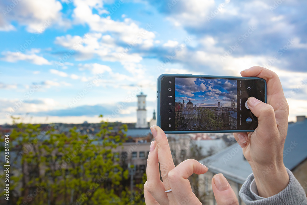 Female hands holding smartphone and making photos in Lviv Female hands holding smartphone and making photos in Lviv