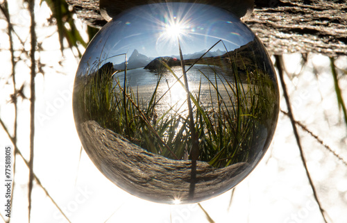 The Matterhorn mountain and surrounding landscape are beautifully captured within a crystal ball under the radiant sun, creating an enchanting inverted image photo