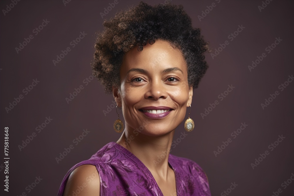 A woman with curly hair and gold earrings is smiling for the camera A woman with curly hair and gold earrings is smiling for the camera