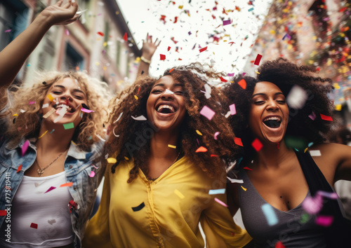 Group of ecstatic women surrounded by a burst of colorful confetti, celebrating.