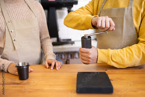 Barista grinding coffee beans with a manual grinder photo