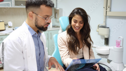Young woman at the dentist's listening to her doctor explaining the x-ray of her teeth