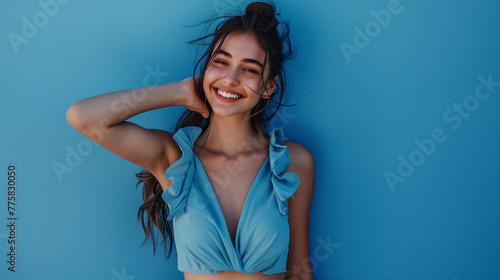 Smiling woman with positive charisma in front of a simple blue background