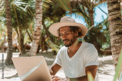 Man working with computer at tropical beach on his vacation. Freelance, work from anywhere concept photo
