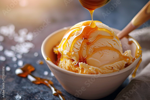 A scoop of creamy caramel ice cream drizzled with salted caramel sauce. photo