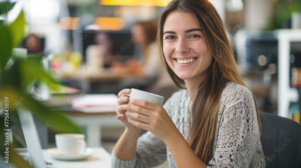 Young Happy Businesswoman Using Computer in Modern Office with Colleagues. Stylish Beautiful Manager Smiling, Working on Financial and Marketing Projects. Drinking Tea or Coffee from a Mug. Young Happy Businesswoman Using Computer in Modern Office with Colleagues. Stylish Beautiful Manager Smiling, Working on Financial and Marketing Projects. Drinking Tea or Coffee from a Mug.
