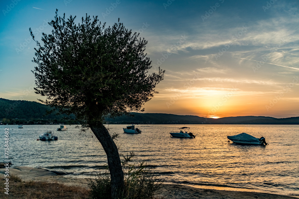Boats, sunset on the beach at summer, Vourvourou, Sithonia sleeve of Khalkidhiki peninsula, Greece. Popular scenery vacation destination
