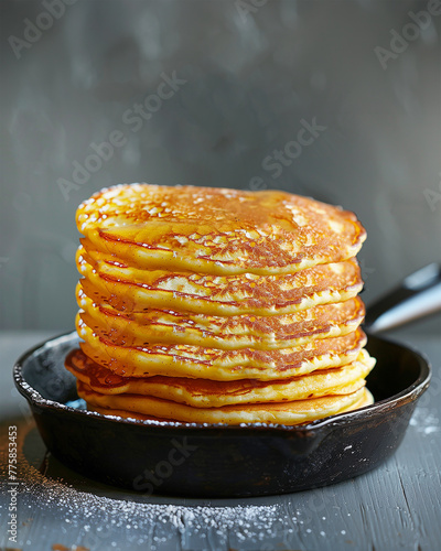 Stack of pancakes in  frying pan at rustic background © VICUSCHKA