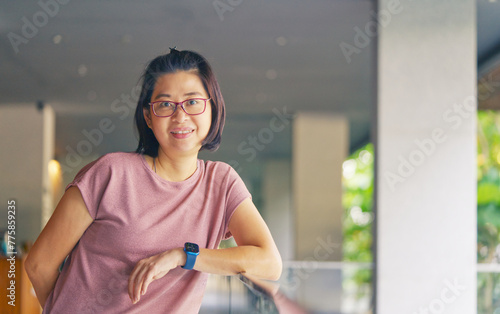 Portrait of a beautiful Asian woman with eyeglasses at a resort, wearing casual, smiling and looking at the camera, middle-aged Asian woman at 38-40 years old, space for copy.