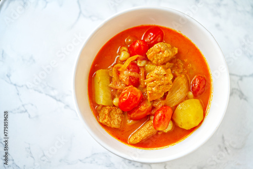Pork Massaman curry, Thai curry with the taste of sweet and a little spicy taste. Tip view image of Massaman curry on a white marble table with natural light.