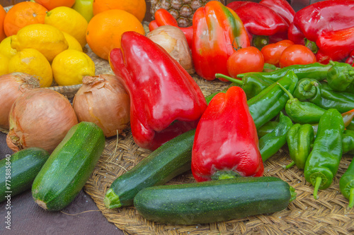 background with various vegetables such as lemons, oranges, onions, zucchini, red and green peppers