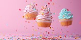 Three delicious cupcakes on a pink background, perfect for bakery or dessert concepts