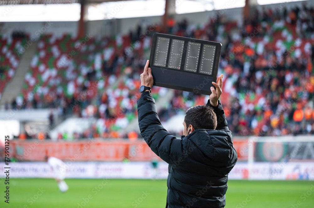 Technical referee shows added time during football match.