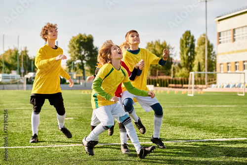 A vibrant group of young individuals enthusiastically playing a game of soccer on a grassy field, running, kicking, and passing the ball with skill and teamwork. © LIGHTFIELD STUDIOS