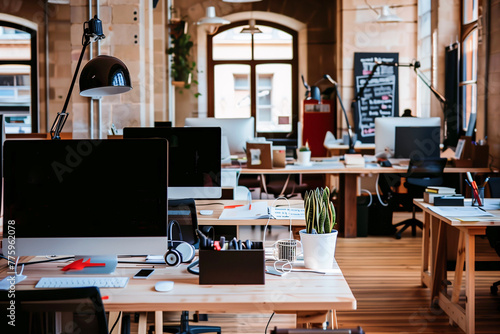 An inviting modern office space with multiple workstations, computers, and decorative plants, promoting productivity and collaboration..