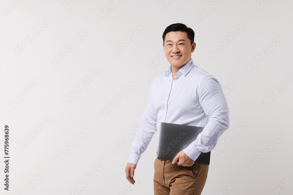 Portrait of happy man with laptop on light background. Space for text Portrait of happy man with laptop on light background. Space for text