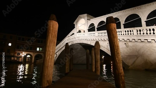 Footage of the Rialto bridge with tourists walking on it in Venice, Italy, at night