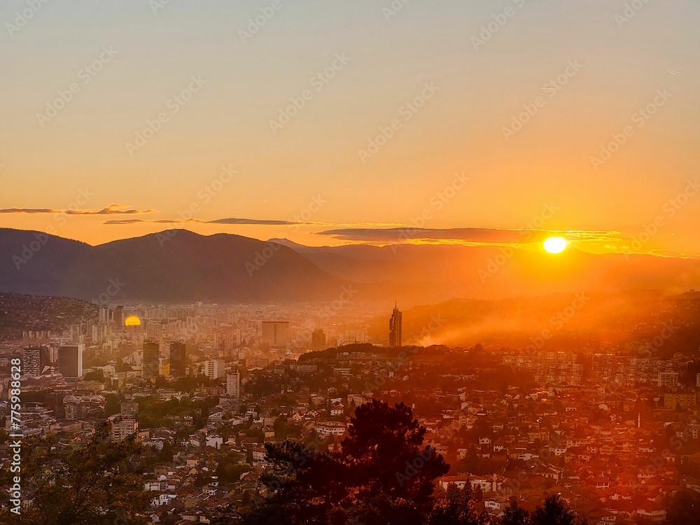 Cityscape and silhouette of hills on the sunset