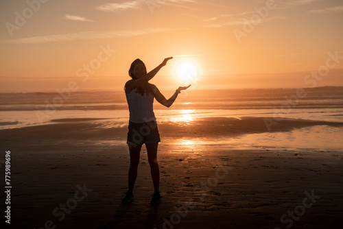 Silhouette di una ragazza mentre regge il sole. photo