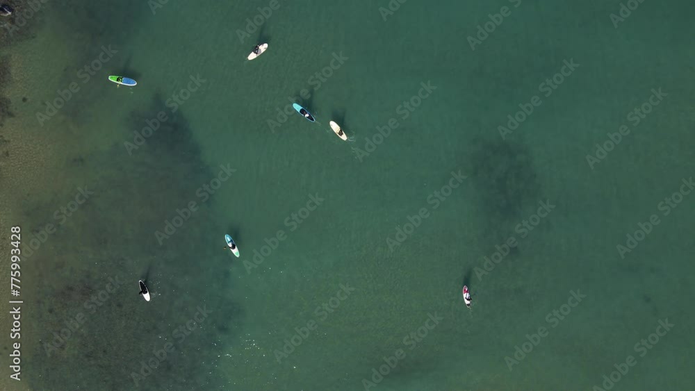 Aerial view by drone of people practicing Stand Up Paddle or SUP in Mediterranean turquoise clear sea. Aerial view by drone of people practicing Stand Up Paddle or SUP in Mediterranean turquoise clear sea.