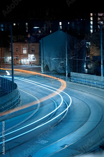 Photography Vertical long exposure of vehicles passing on a calm street in Oslo at night
