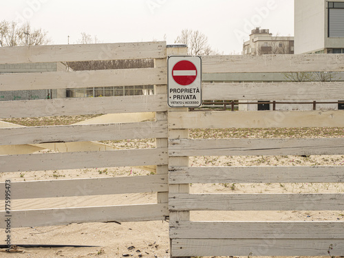 Segnale di proprietà privata con divieto di accesso su una recinzione di legno in una spiaggia. photo