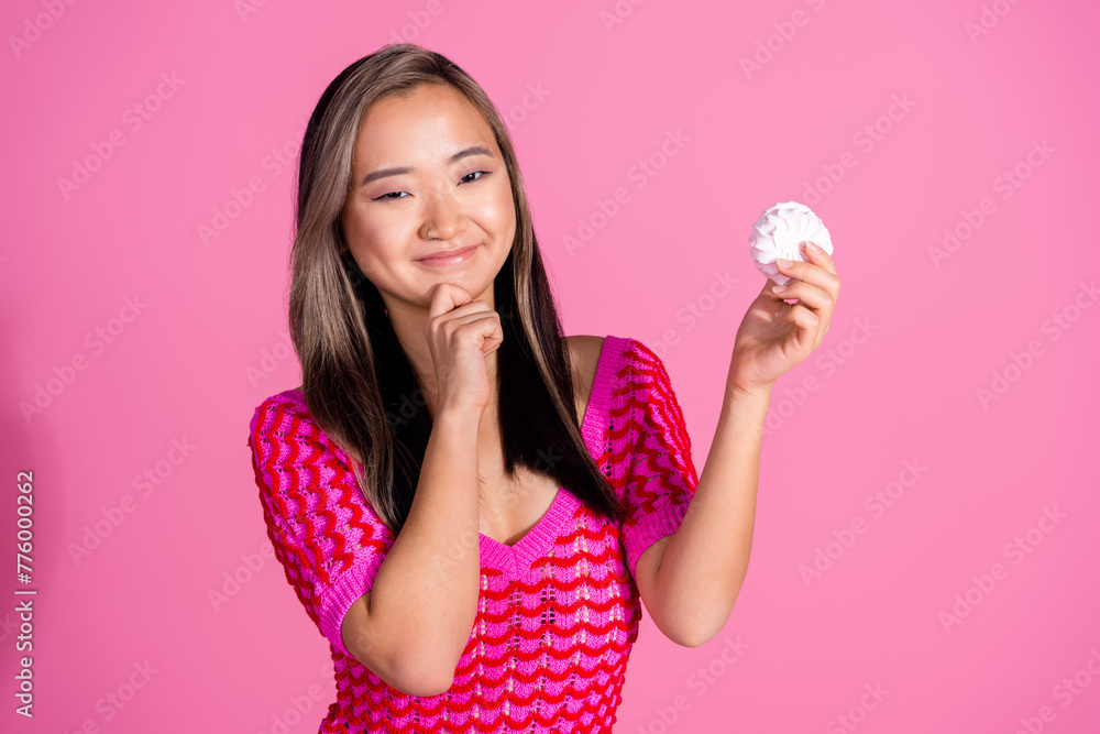 Photo of cheerful positive lady dressed knitted shirt arm chin holding tasty marshmallow isolated pink color background Photo of cheerful positive lady dressed knitted shirt arm chin holding tasty marshmallow isolated pink color background