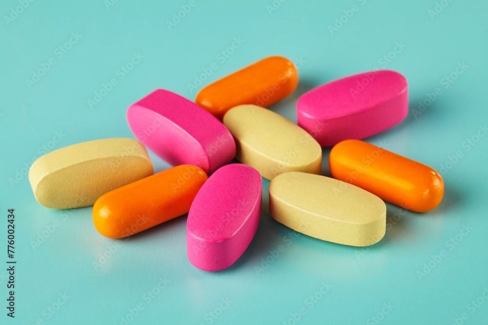 Closeup shot of colorful medicines and vitamins on the cyan background Closeup shot of colorful medicines and vitamins on the cyan background