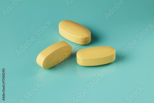 Canvastavla Closeup shot of three medicinal caplets on the cyan background