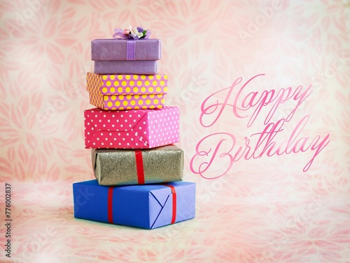 Photography View of stacked gift boxes in floral background with 'happy birthday' text