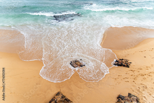 A high-angle shot of rocks and waves on Rio Vermelho beach in Salvador, Bahia, Brazil. photo