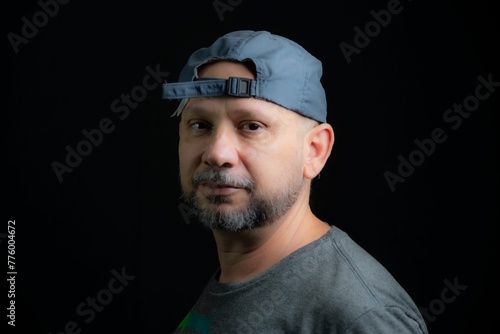 Portrait of a bald bearded man looking at the camera against a black background