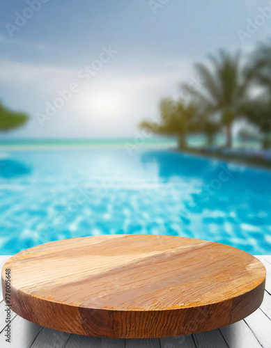 Blurry background image of a brown wooden table near a poolside on a beach resort., space for text © anandart