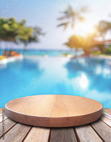 Blurry background image of a brown wooden table near a poolside on a beach resort., space for text