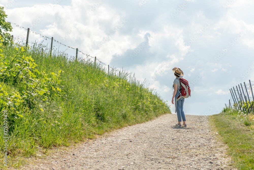 Hiker with a backpack walking on a countryside road