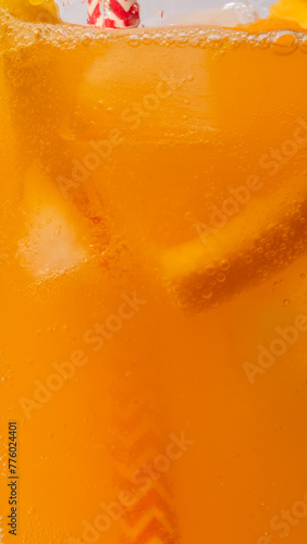 Lemonade pours into a glass with ice and a slice of orange, drink photography