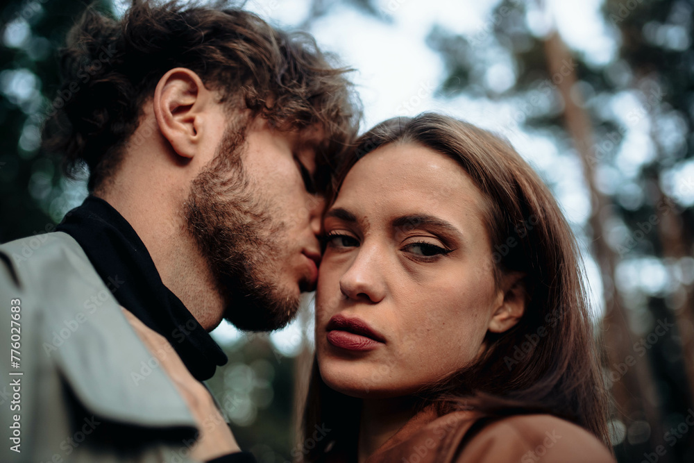 couple in love in the forest at sunset on a date hugging in a coat in the summer. Cinematic love story couple in love in the forest at sunset on a date hugging in a coat in the summer. Cinematic love story