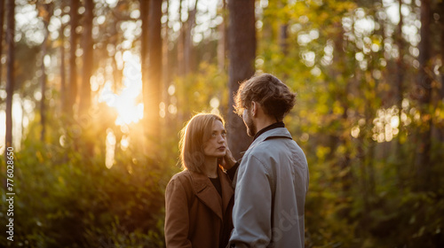 couple in love in the forest at sunset on a date hugging in a coat in the summer. Cinematic love story © velimir