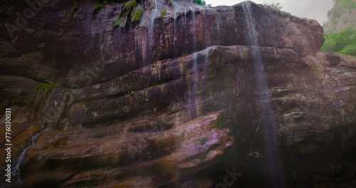 Chegem waterfalls. An amazing stream of water flows like a waterfall from a stone wall directly into a stormy river. Russia. Caucasus. Kabardino-Balkarian Republic. photo