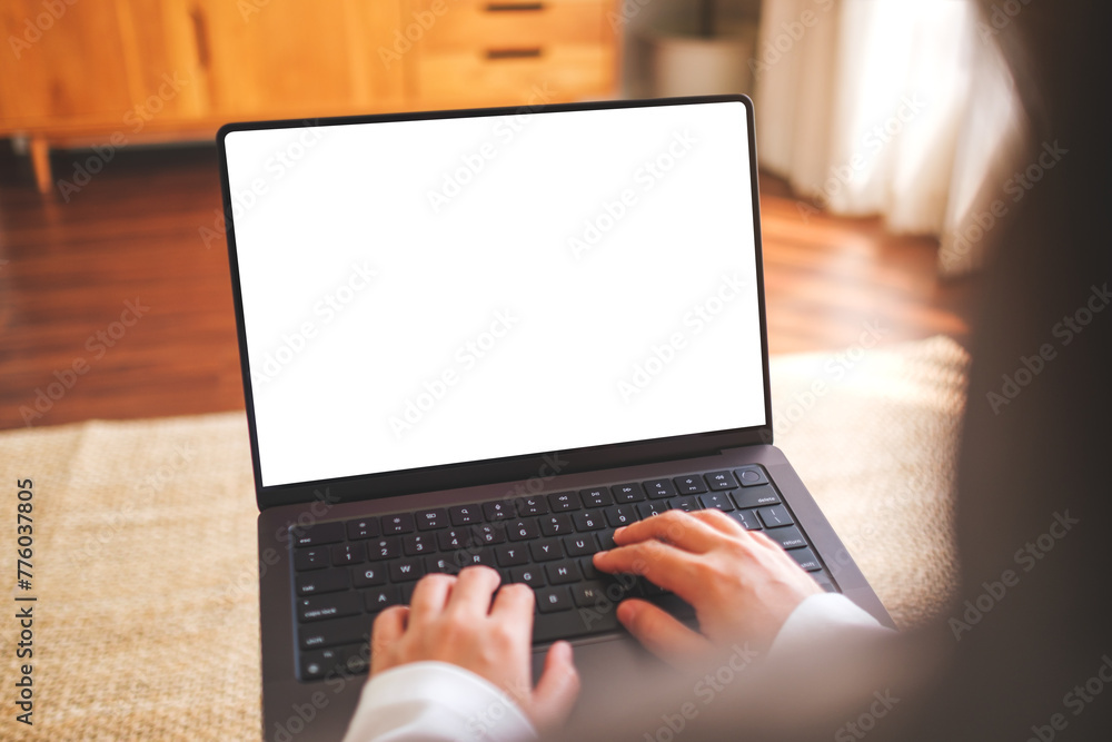 Mockup image of a woman working and typing on laptop computer with blank white desktop screen at home Mockup image of a woman working and typing on laptop computer with blank white desktop screen at home