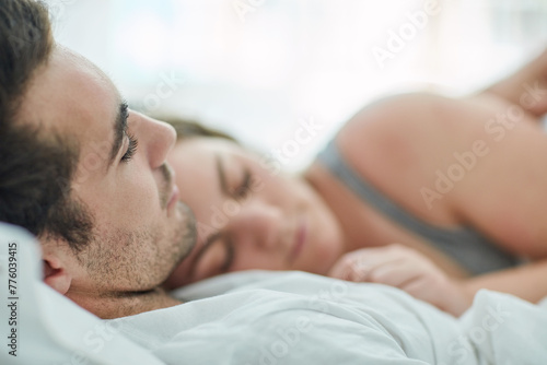 Sleeping, love and couple hug in bed with peace, safety and security, comfort and bonding in their home. Relax, sleep and people in bedroom with nap, snooze or lazy morning, dream or rest in a house