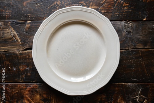 A white porcelain plate is placed on top of a wooden table, highlighting the contrast between the clean design of the plate and the grainy texture of the table