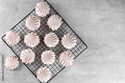Russian sweet dessert - pink marshmallow zephyr on gray background. Meringue, souffle dessert. Top view.