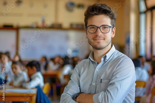 Portrait of a young male teacher standing in a classroom at school