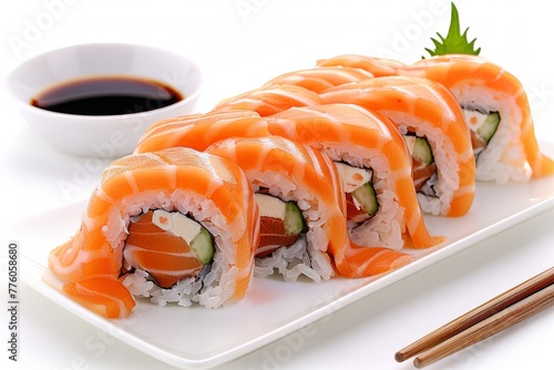A close-up of sushi rolls with salmon and cucumber, wrapped in seaweed and served with soy sauce.