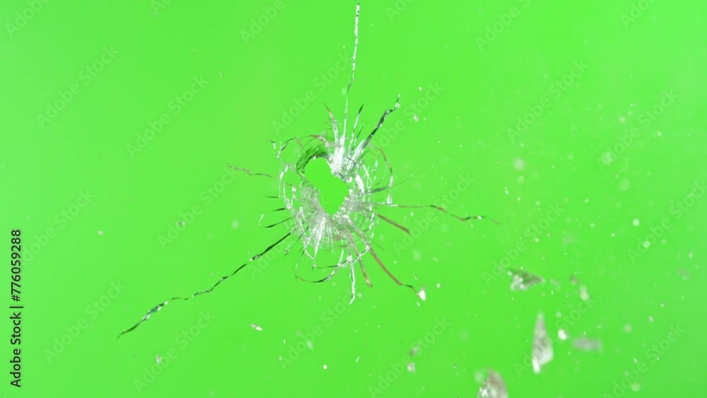 Super slow motion of gunshot through the glass, shattering against green screen background . Filmed on high speed cinema camera, 1000 fps.